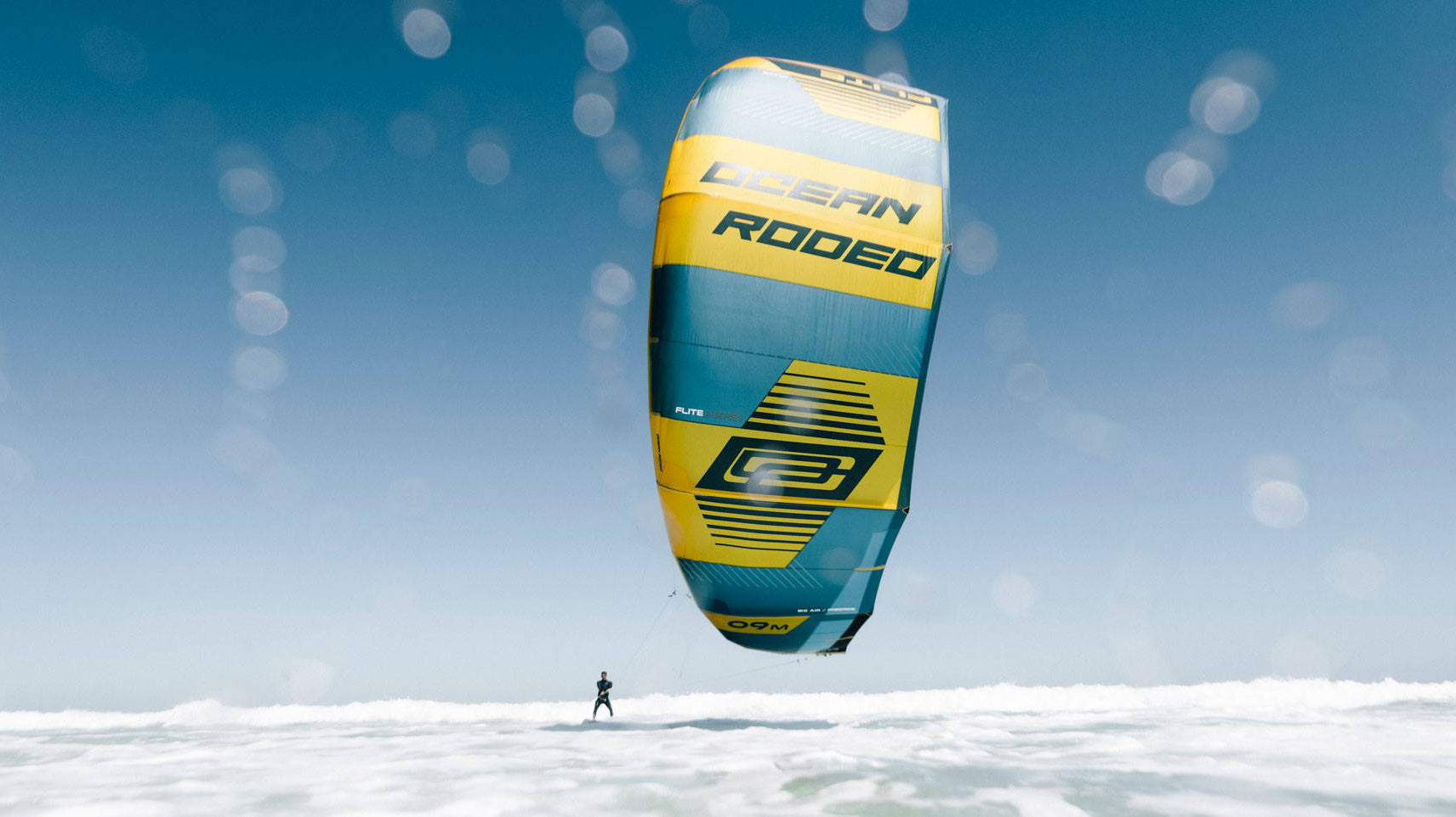 Ocean Rodeo kite above white water.